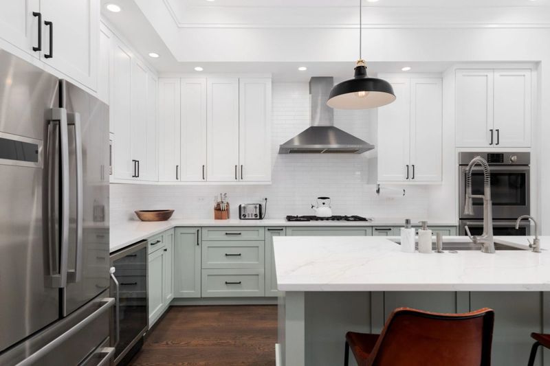 Modern kitchen with white countertops and green cabinetry
